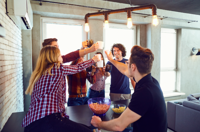 Royalty free image from Canva of a group of young adults raising their coffee mugs in a toast