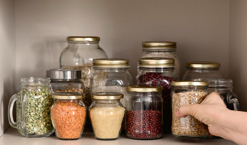 Free image from canva of glass jars with grains and pulses in them in an open cupboard