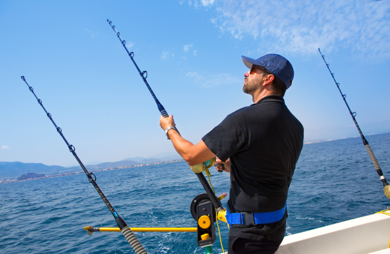 Sustainable Fishing Methods - stock image of a man in a boat fishing with a rod