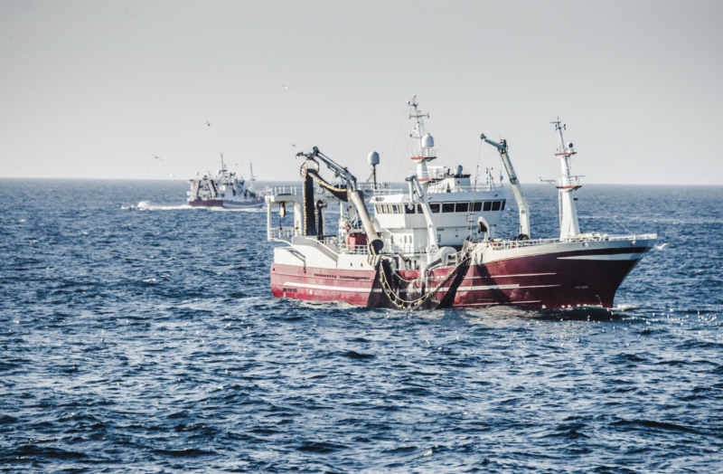 Sustainable Fishing Methods - stock image of a shipping vessel using a purse seine net