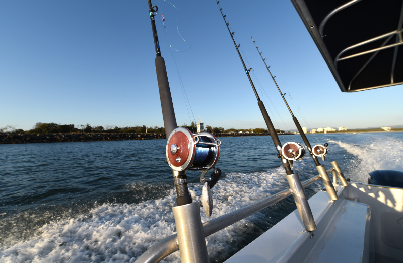 Sustainable Fishing Methods - stock image of several rods standing on the side of a boat fishing 