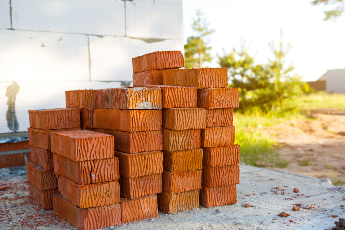 Storing Building Materials - Stock Image from Canva of a small stack of bricks outside a house