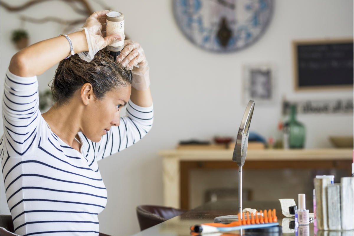 Vegan hair dye - image from Canva of a woman colouring her own hair at home