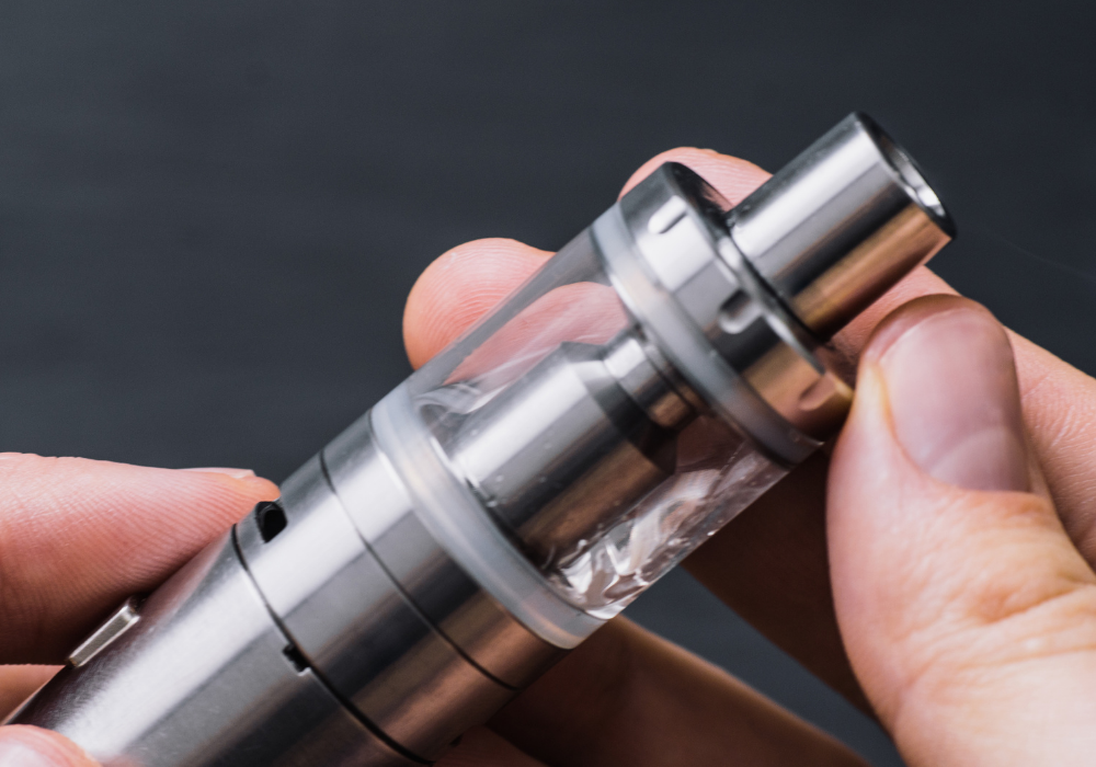 Recycling vapes - image of a metal vape with a glass cartridge in a mans hands