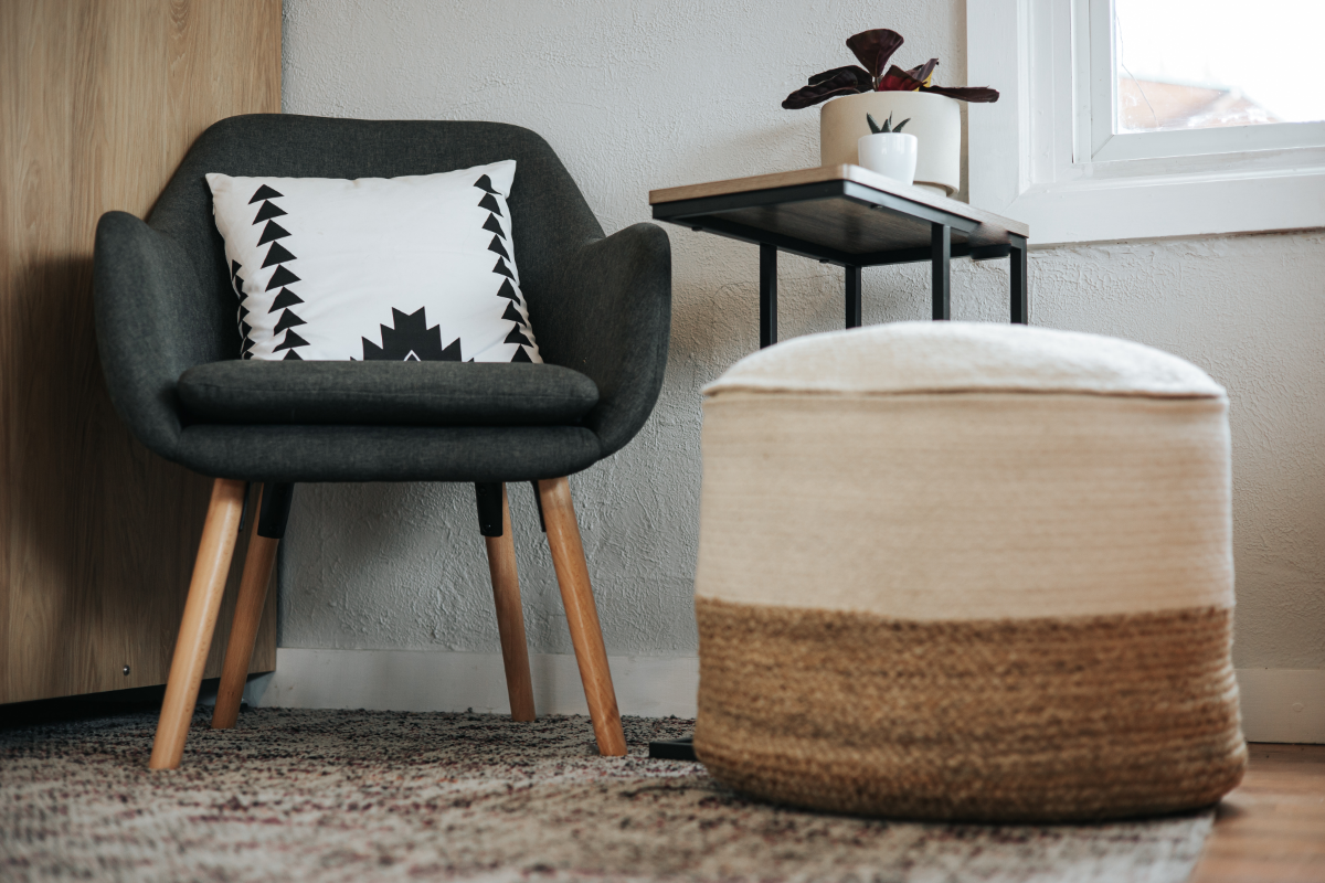 Recycled Plastic Products - Stock Image from, Canva of a minimalist chair on a woven rug with a geometric print cushion