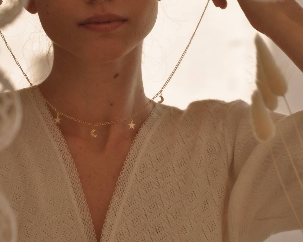 Ethical Jewelry - Stock Image from Canva of a woman putting on a delicate gold chain