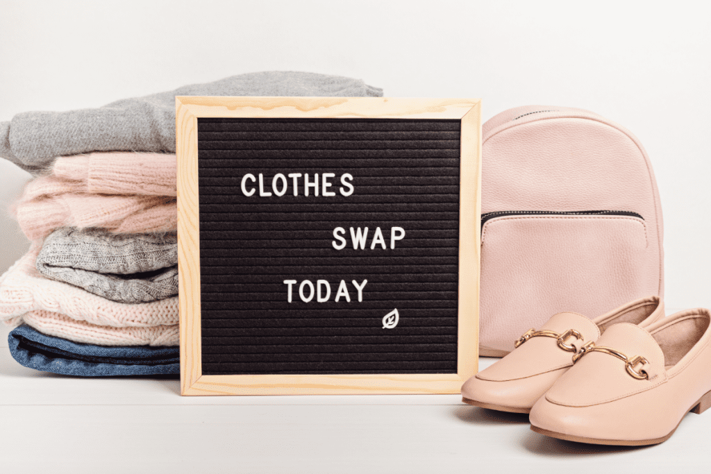 Sustainable and ethical fashion - image of a pile of folded clothes with a sign that says "clothes swap today"