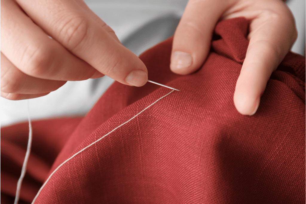 Sustainable and ethical fashion - image of hands sewing fabric by hand