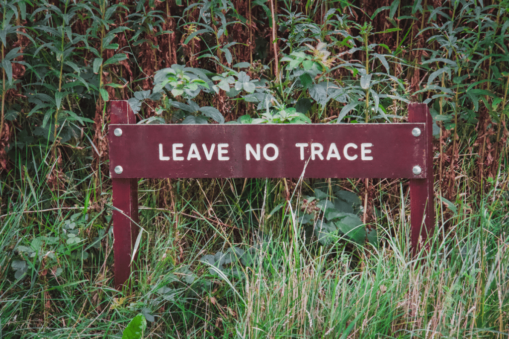 Sustainable Travel - sign that says 'leave no trace' next to a hiking trail