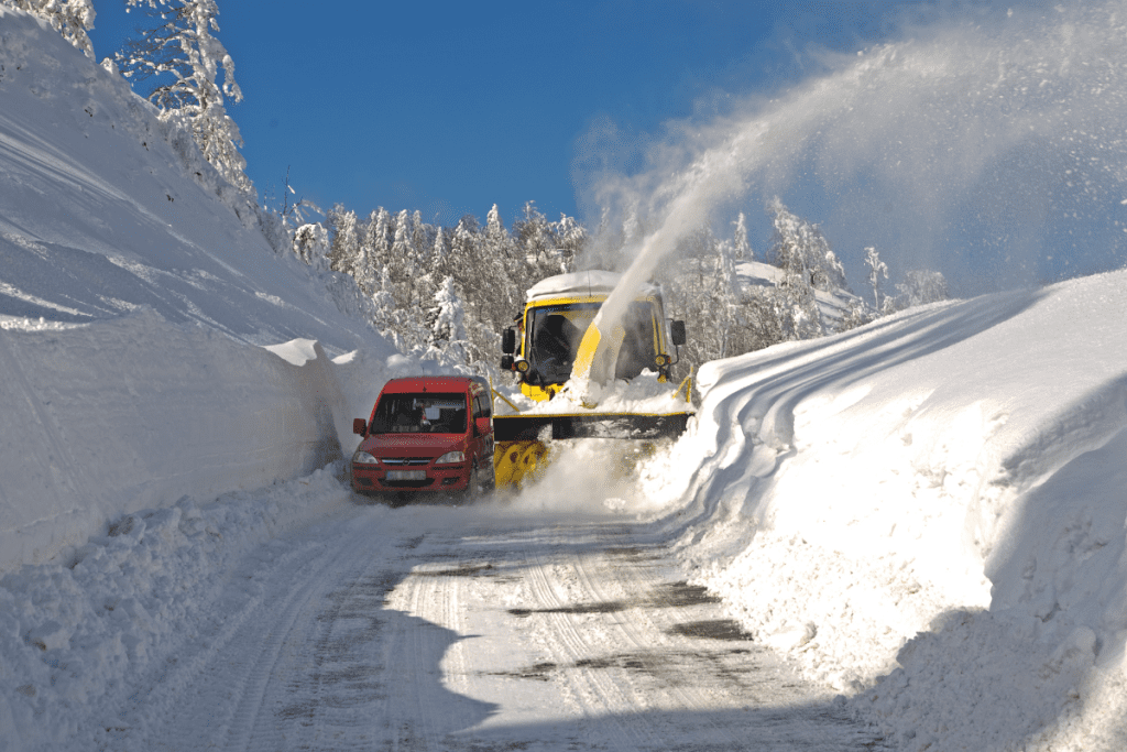 Weather Forecasting - Image of a snow plough clearing deep snow on the roads