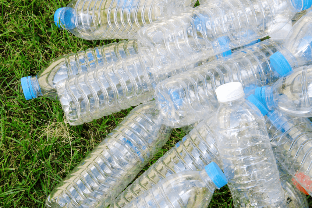 Water filter benefits - stock image of a pile of clear plastic water bottles on the grass