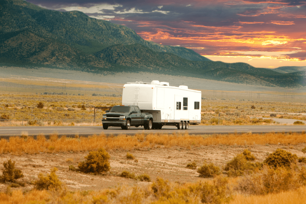 Eco-friendly trailer conversion - stock image from Canva of a truck and trailer under a sunset sky in the wilderness