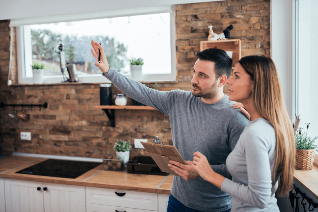 Eco-friendly Renovations - Image of a couple in kitchen with a clipboard, planning a project