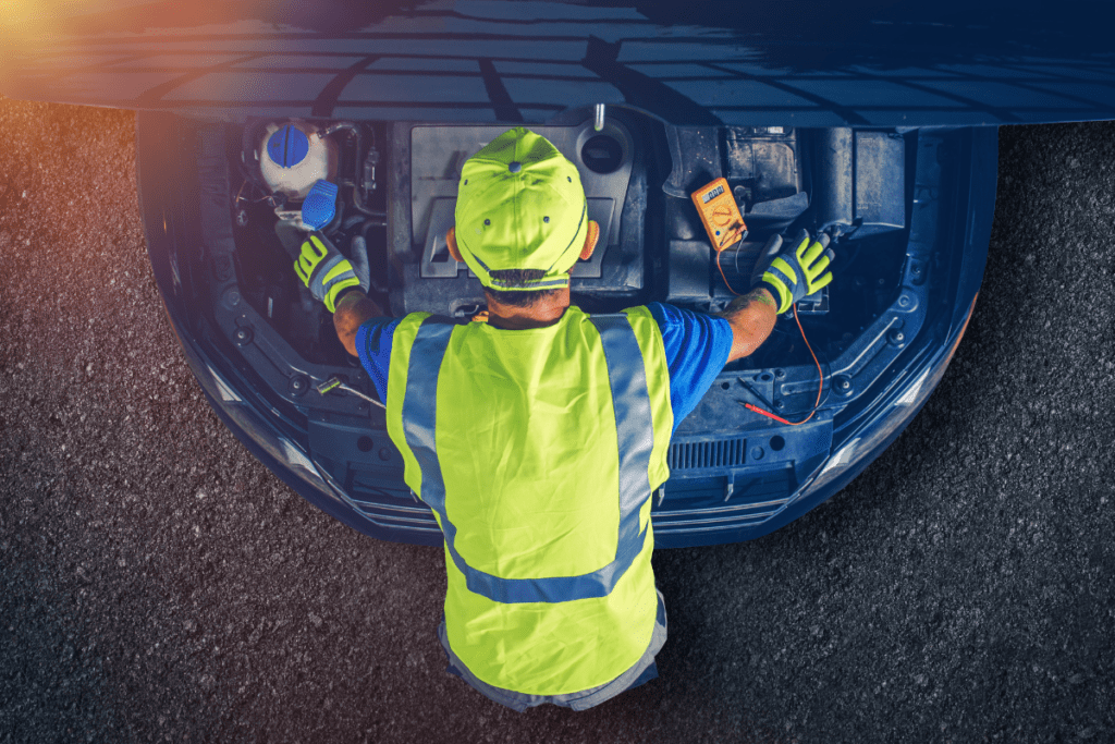 reasons to switch to an electric car - stock image from Canva of an electric vehicle engine bay and a man leaning over it