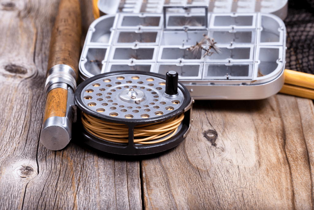 eco-friendly bass fishing - image of a fishing reel and a bait/fly box