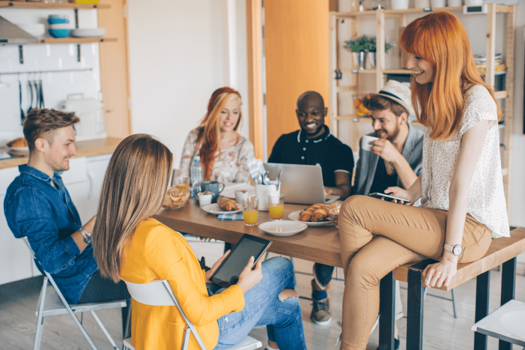 Coliving in Brooklyn - group of adults hanging out together around the kitchen table
