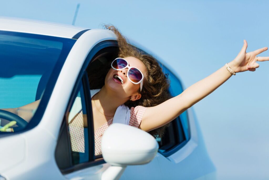 A lady driving a car with windows open