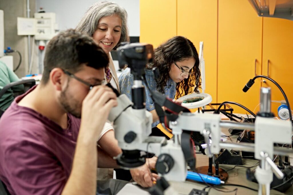 A male student observing environmental specimen in a laboratory microscope
