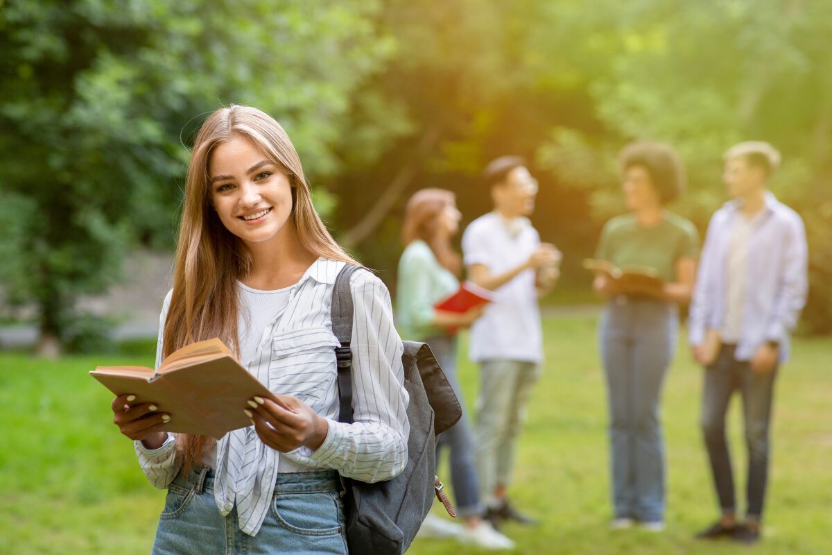 A female scholar holding a book, a group of students in the background