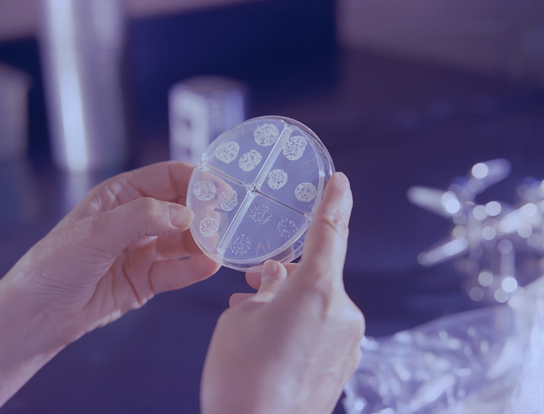a person holding a round bacterial testing petri dish in their hands