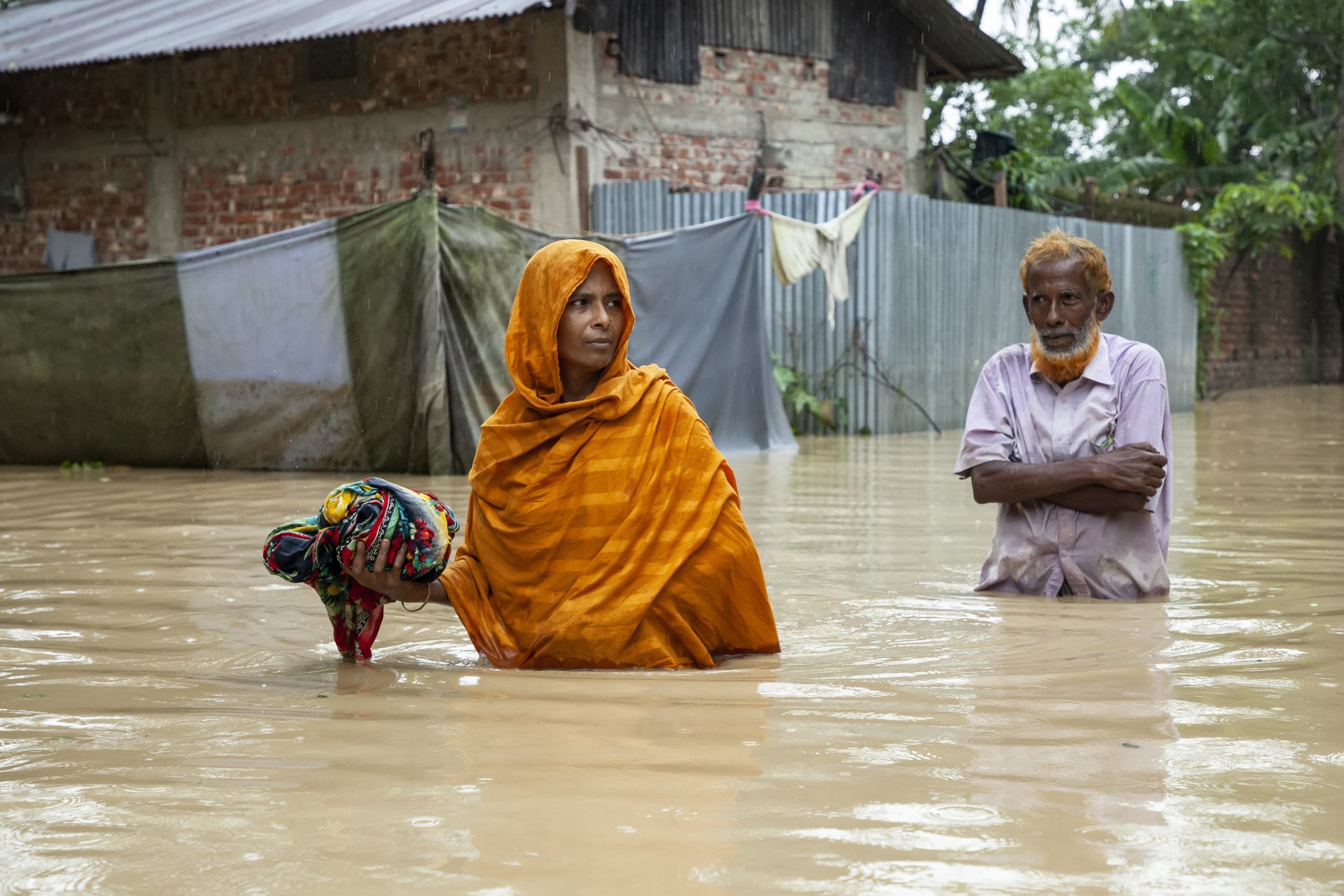 Bangladesh:Pedestrians walk through flooded roads