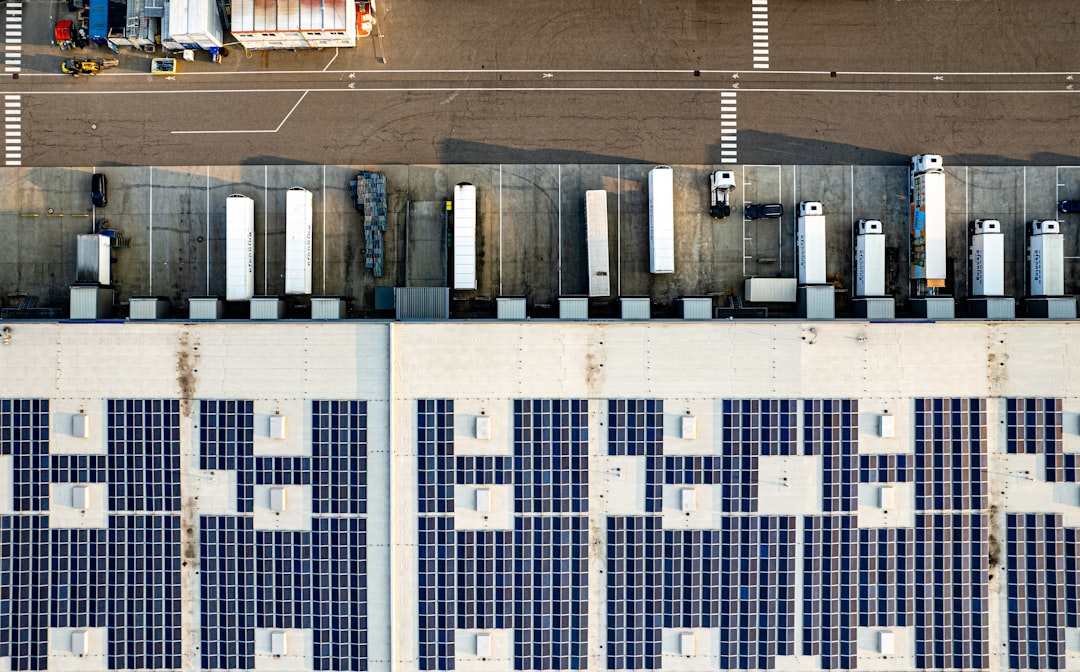 An aerial view of a warehouse with lots of solar panels